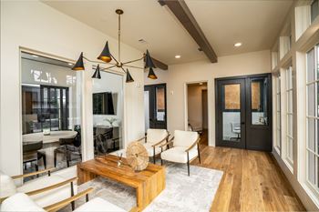 a living room with a table and chairs and a large window